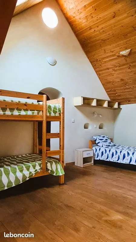 Chambre enfants du gîte avec lits superposés et lit simple sous les combles