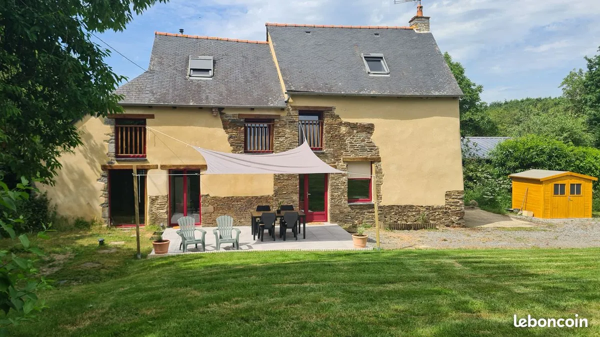 Façade en pierre du gîte de Pleugueneuc avec sa terrasse et son jardin